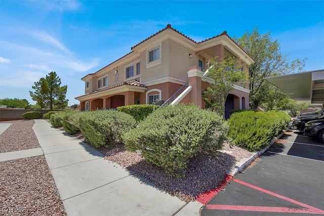 10553 Pine Glen Ave Unit 101, Las Vegas, NV 89144 - view of front facade with stucco siding, a tile roof, and a parking lot
