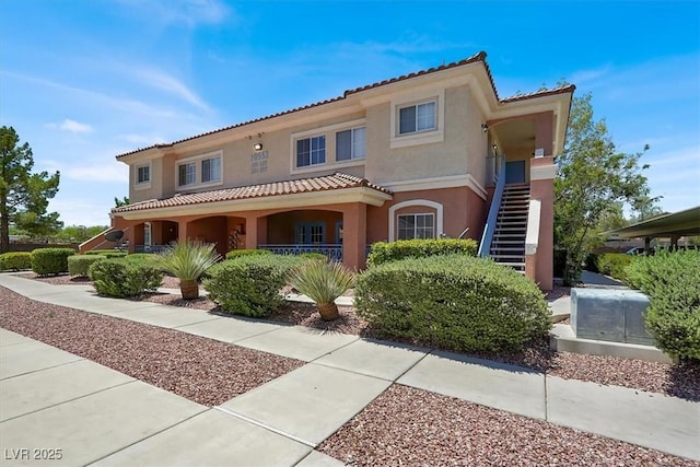 10553 Pine Glen Ave Unit 101, Las Vegas, NV 89144 - mediterranean / spanish-style house featuring stucco siding, a tiled roof, a porch, and stairs