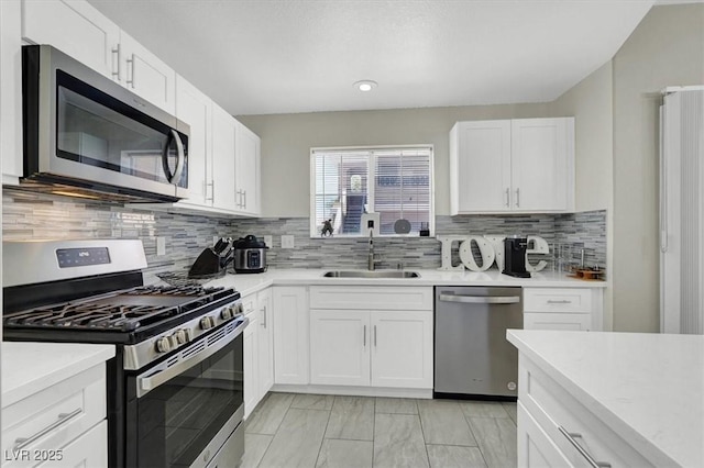 10553 Pine Glen Ave Unit 101, Las Vegas, NV 89144 - kitchen featuring stainless steel appliances, light countertops, white cabinetry, tasteful backsplash, and light marble finish floors