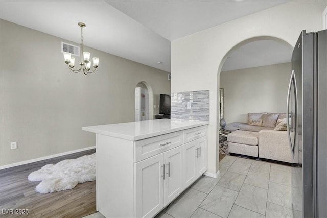 10553 Pine Glen Ave Unit 101, Las Vegas, NV 89144 - kitchen with freestanding refrigerator, arched walkways, open floor plan, white cabinetry, and light countertops