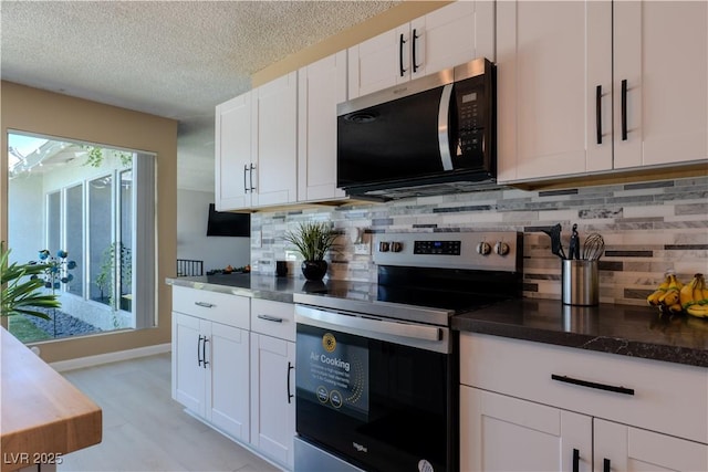 3030 Liberty Cir, Las Vegas, NV 89121 - kitchen with appliances with stainless steel finishes, white cabinets, backsplash, a textured ceiling, and dark countertops