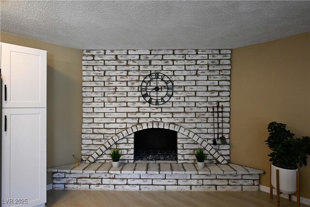3030 Liberty Cir, Las Vegas, NV 89121 - unfurnished living room featuring a brick fireplace, a textured ceiling, and wood finished floors