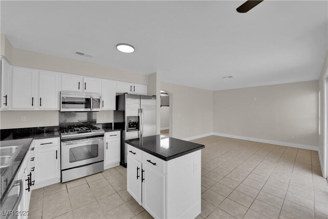 8379 Drop Camp St, Las Vegas, NV 89123 - kitchen featuring stainless steel appliances, light tile patterned floors, dark countertops, white cabinetry, and open floor plan