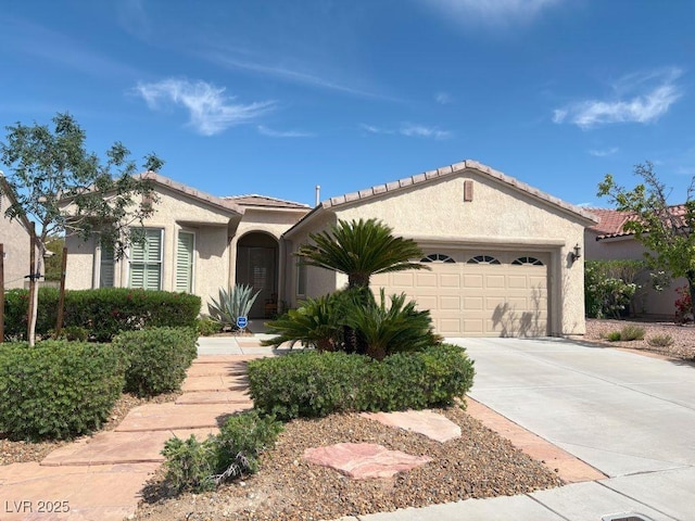 5110 Silenzio St, Las Vegas, NV 89135 - view of front of property featuring an attached garage, driveway, stucco siding, and a tiled roof