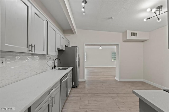 1628 Izabella Ave, Las Vegas, NV 89169 - kitchen featuring decorative backsplash, light wood-style flooring, stainless steel appliances, light countertops, and a textured ceiling
