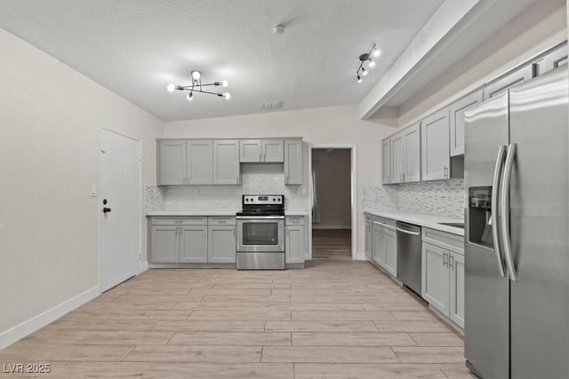 1628 Izabella Ave, Las Vegas, NV 89169 - kitchen featuring appliances with stainless steel finishes, gray cabinetry, tasteful backsplash, light countertops, and a textured ceiling