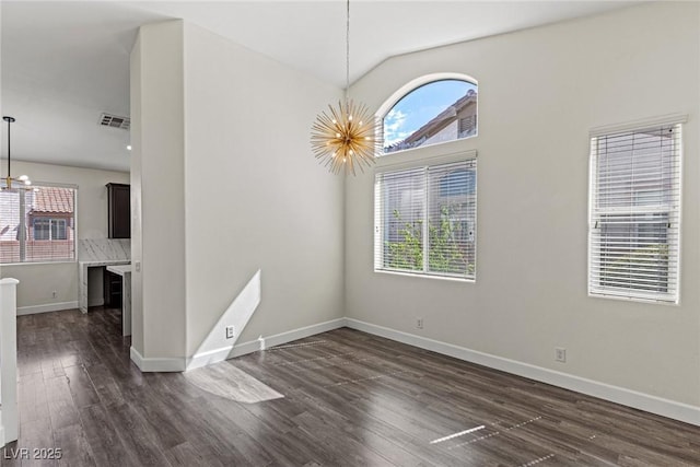 11484 Roncat Ct, Las Vegas, NV 89141 - empty room with a chandelier, healthy amount of natural light, lofted ceiling, and dark wood-style flooring