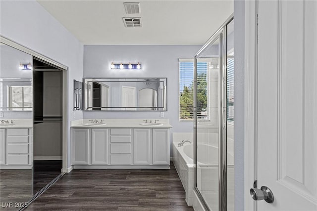 11484 Roncat Ct, Las Vegas, NV 89141 - bathroom with double vanity, wood finished floors, a bath, and a shower stall