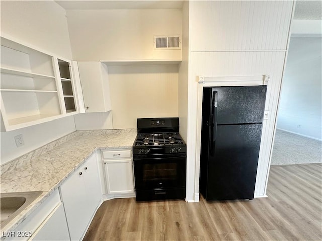4924 Carmen Blvd, Las Vegas, NV 89108 - kitchen with black appliances, light wood-style floors, white cabinetry, and open shelves