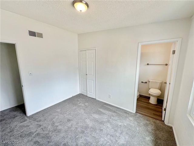 4924 Carmen Blvd, Las Vegas, NV 89108 - unfurnished bedroom featuring carpet, a closet, a textured ceiling, and ensuite bathroom