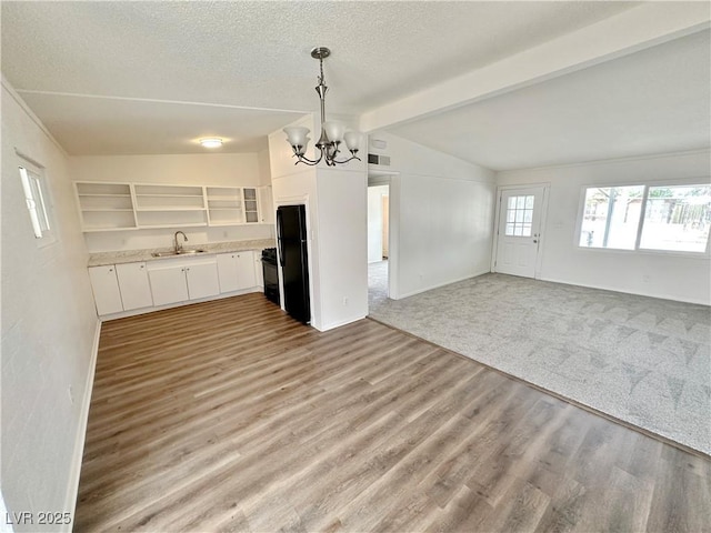 4924 Carmen Blvd, Las Vegas, NV 89108 - kitchen featuring freestanding refrigerator, a chandelier, open floor plan, light countertops, and white cabinetry