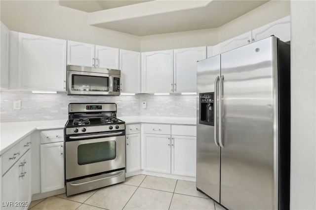 4753 Carefree Dr, Las Vegas, NV 89122 - kitchen with stainless steel appliances, white cabinets, light tile patterned floors, light countertops, and decorative backsplash