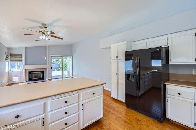 8309 Windrush Ave, Las Vegas, NV 89117 - kitchen featuring black fridge, a ceiling fan, and white cabinetry