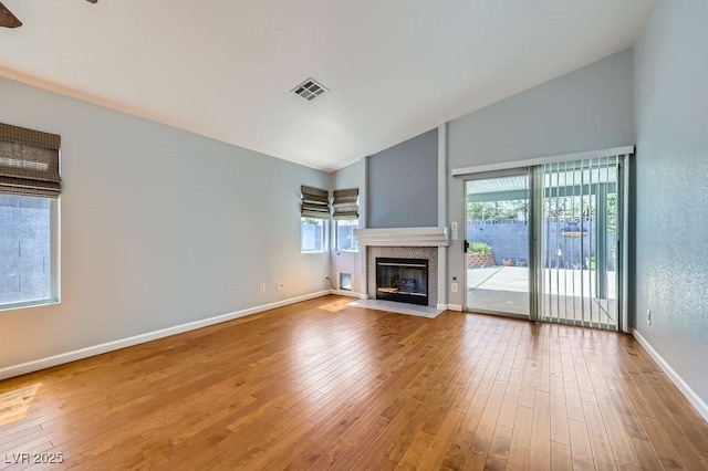 8309 Windrush Ave, Las Vegas, NV 89117 - unfurnished living room featuring a fireplace, wood finished floors, and high vaulted ceiling