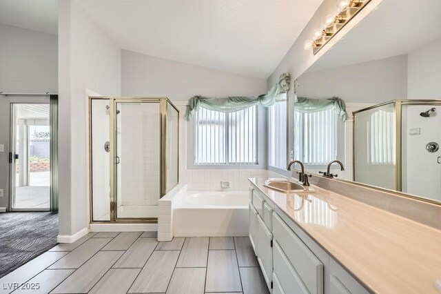 8309 Windrush Ave, Las Vegas, NV 89117 - bathroom with vaulted ceiling, a shower stall, a bath, and vanity