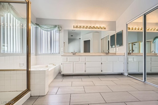 8309 Windrush Ave, Las Vegas, NV 89117 - full bathroom with double vanity, a bath, a shower stall, and tile patterned flooring