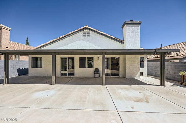 8309 Windrush Ave, Las Vegas, NV 89117 - back of property with a chimney, a patio area, stucco siding, and a tile roof