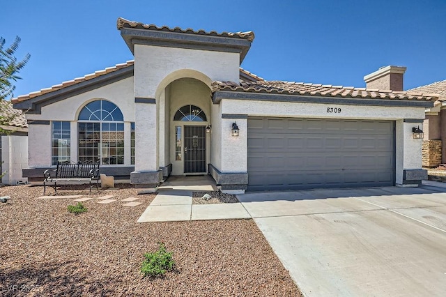 8309 Windrush Ave, Las Vegas, NV 89117 - mediterranean / spanish-style house featuring concrete driveway, a tiled roof, stucco siding, and an attached garage