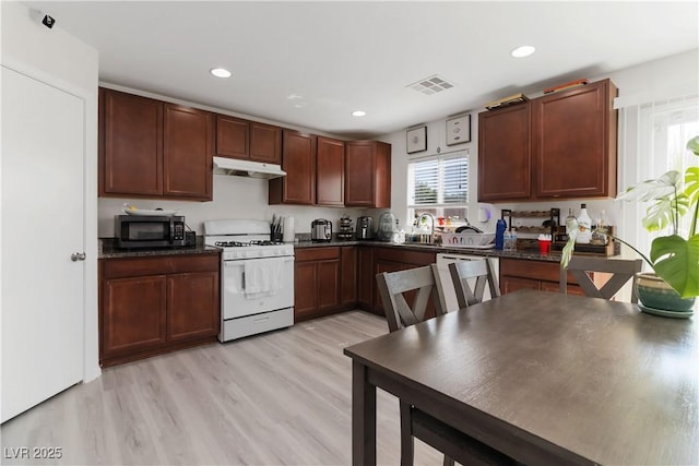 4976 Quiet Morning St, Las Vegas, NV 89122 - kitchen featuring white gas stove, under cabinet range hood, black microwave, healthy amount of natural light, and recessed lighting