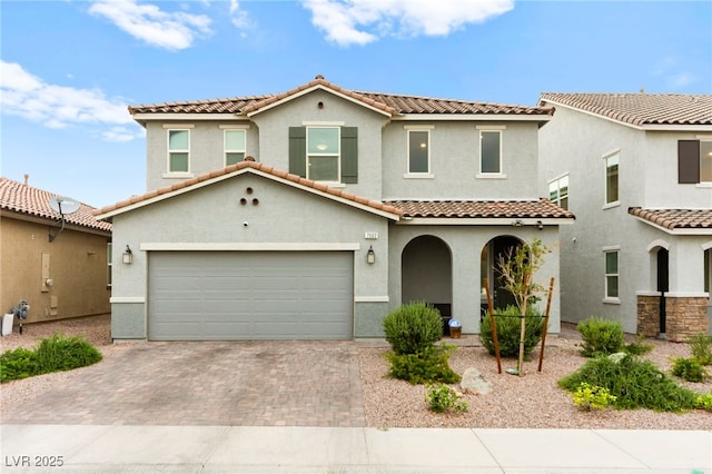 7502 Lush Oasis Ave, Las Vegas, NV 89113 - mediterranean / spanish-style home featuring decorative driveway, stucco siding, a tiled roof, a garage, and a porch