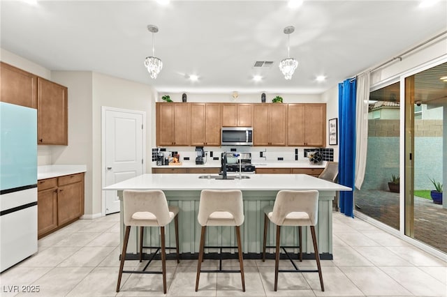 7502 Lush Oasis Ave, Las Vegas, NV 89113 - kitchen featuring appliances with stainless steel finishes, light countertops, and brown cabinets
