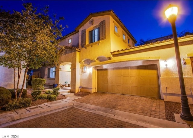 1557 Blue Sierra Ct, Henderson, NV 89074 - mediterranean / spanish home featuring stucco siding, a tile roof, decorative driveway, and a garage
