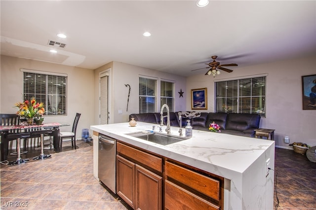 1557 Blue Sierra Ct, Henderson, NV 89074 - kitchen with stainless steel dishwasher, a ceiling fan, open floor plan, recessed lighting, and brown cabinets