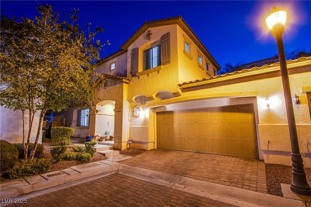 1557 Blue Sierra Ct, Henderson, NV 89074 - mediterranean / spanish-style house featuring stucco siding, a tiled roof, and decorative driveway