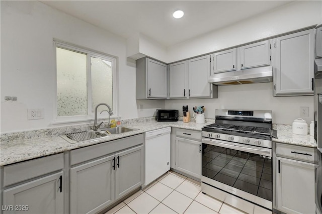 7066 Burcot Ave Unit 59, Las Vegas, NV 89156 - kitchen with stainless steel gas range, under cabinet range hood, white dishwasher, gray cabinetry, and light tile patterned floors