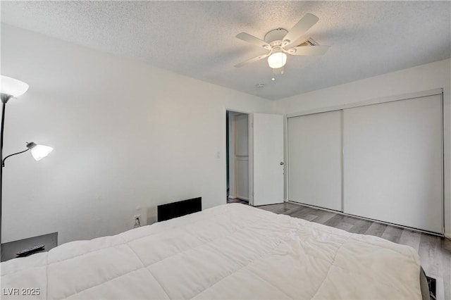 7066 Burcot Ave Unit 59, Las Vegas, NV 89156 - bedroom with wood finished floors, a textured ceiling, a closet, and a ceiling fan