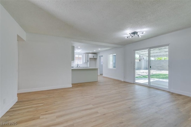212 View Dr, Las Vegas, NV 89107 - unfurnished living room featuring a textured ceiling and light wood-style flooring
