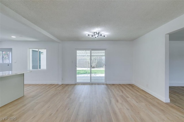 212 View Dr, Las Vegas, NV 89107 - unfurnished living room with a textured ceiling, light wood-style floors, and plenty of natural light