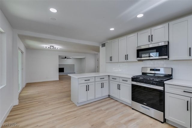 212 View Dr, Las Vegas, NV 89107 - kitchen with appliances with stainless steel finishes, a peninsula, open floor plan, light countertops, and tasteful backsplash