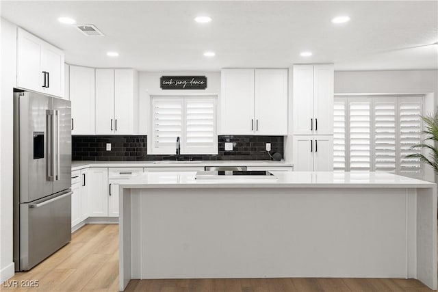 1990 Freeman Ct, Henderson, NV 89014 - kitchen with high end fridge, white cabinets, backsplash, light wood-style flooring, and light countertops