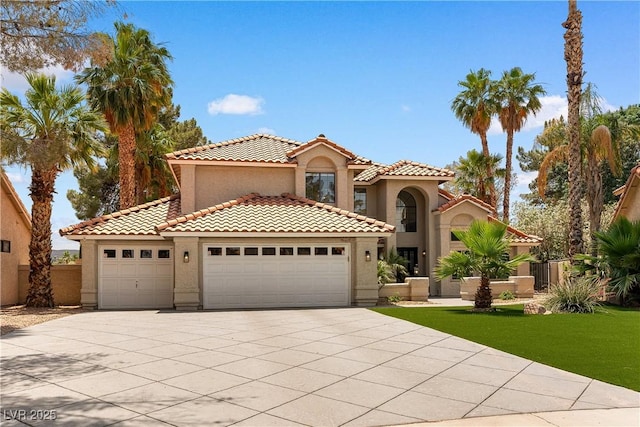 1990 Freeman Ct, Henderson, NV 89014 - mediterranean / spanish home featuring an attached garage, stucco siding, concrete driveway, a tiled roof, and a front yard