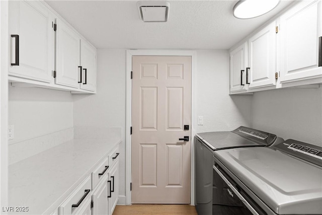 1990 Freeman Ct, Henderson, NV 89014 - laundry area with washing machine and dryer, cabinet space, light wood-style flooring, and a textured ceiling