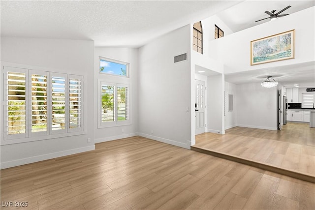 1990 Freeman Ct, Henderson, NV 89014 - unfurnished living room with light wood-style flooring, high vaulted ceiling, and a chandelier
