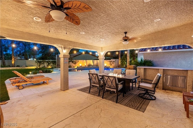 1990 Freeman Ct, Henderson, NV 89014 - patio at night with outdoor dining area, a patio, and ceiling fan