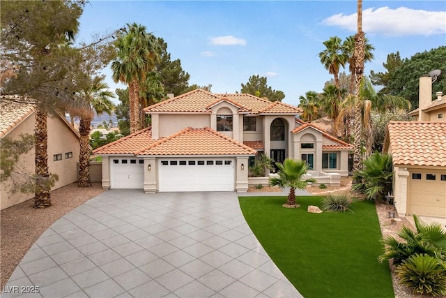 1990 Freeman Ct, Henderson, NV 89014 - mediterranean / spanish-style house featuring stucco siding, a tile roof, a front lawn, an attached garage, and concrete driveway