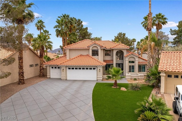 1990 Freeman Ct, Henderson, NV 89014 - mediterranean / spanish house featuring a tile roof, stucco siding, an attached garage, and driveway