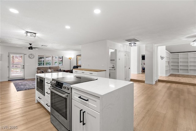 1990 Freeman Ct, Henderson, NV 89014 - kitchen featuring appliances with stainless steel finishes, open floor plan, white cabinets, ceiling fan, and recessed lighting