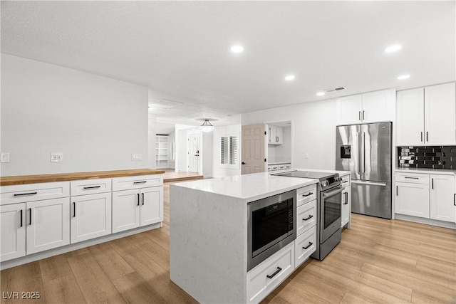 1990 Freeman Ct, Henderson, NV 89014 - kitchen with stainless steel appliances, recessed lighting, tasteful backsplash, white cabinetry, and light wood-style floors