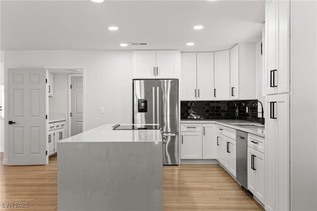 1990 Freeman Ct, Henderson, NV 89014 - kitchen with appliances with stainless steel finishes, recessed lighting, a center island, light wood-type flooring, and decorative backsplash