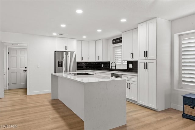 1990 Freeman Ct, Henderson, NV 89014 - kitchen with stainless steel appliances, a kitchen island, light wood-style floors, white cabinets, and recessed lighting
