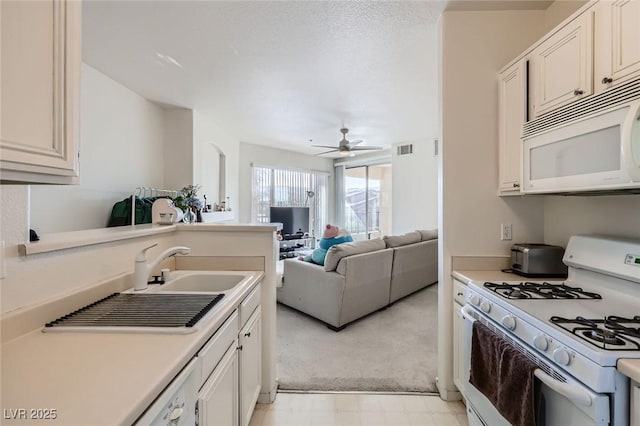 7127 S Durango Dr Unit 310, Las Vegas, NV 89113 - kitchen with white appliances, a ceiling fan, light countertops, and light carpet
