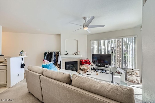 7127 S Durango Dr Unit 310, Las Vegas, NV 89113 - living area with a ceiling fan, a tiled fireplace, and light colored carpet