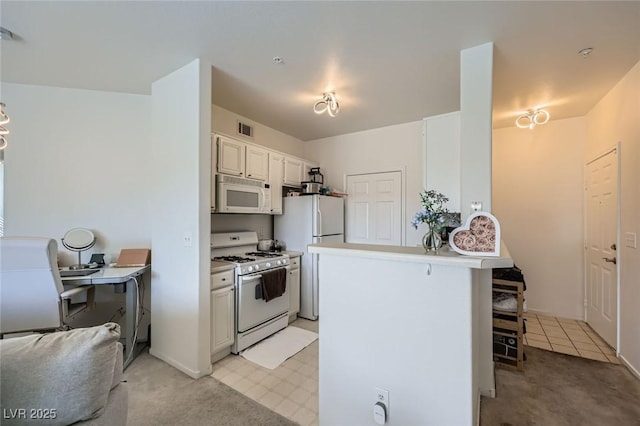 7127 S Durango Dr Unit 310, Las Vegas, NV 89113 - kitchen with white appliances, a breakfast bar area, a peninsula, light colored carpet, and light countertops