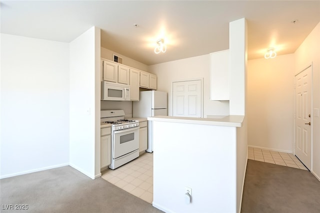 7127 S Durango Dr Unit 310, Las Vegas, NV 89113 - kitchen with white appliances, light carpet, light countertops, and a peninsula