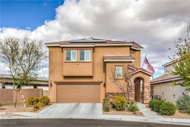 7948 Eastern Elk St, Las Vegas, NV 89149 - view of front facade featuring driveway, roof mounted solar panels, an attached garage, stucco siding, and stone siding