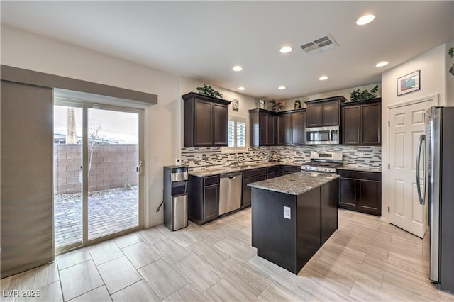 7948 Eastern Elk St, Las Vegas, NV 89149 - kitchen with appliances with stainless steel finishes, a kitchen island, tasteful backsplash, light stone counters, and recessed lighting
